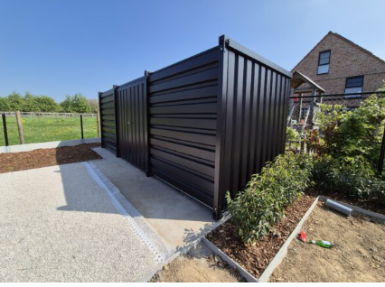 Container in RAL-kleur naast een woning